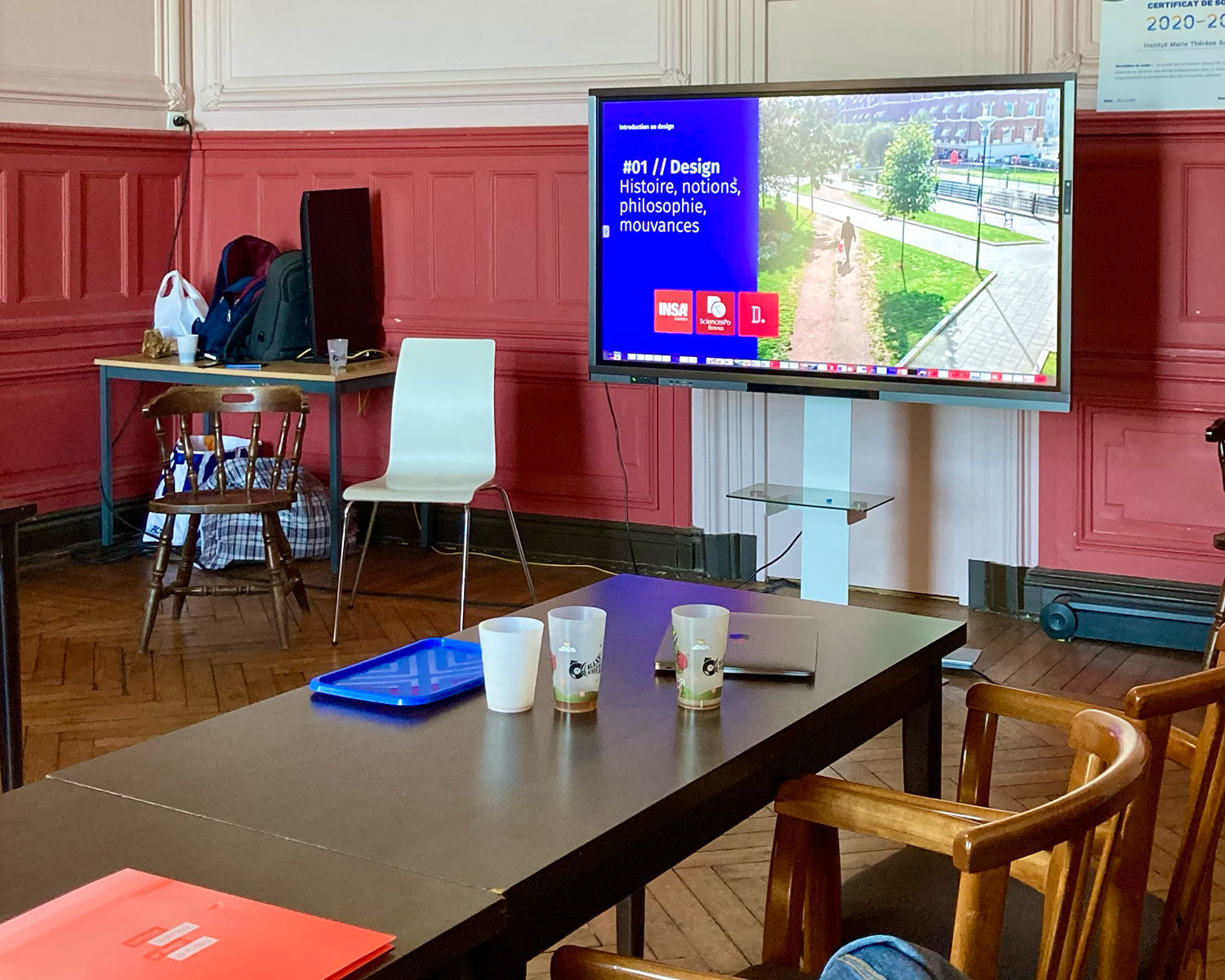 Présentation d'un projet de design devant un petit groupe, écran affichant du code et des visuels